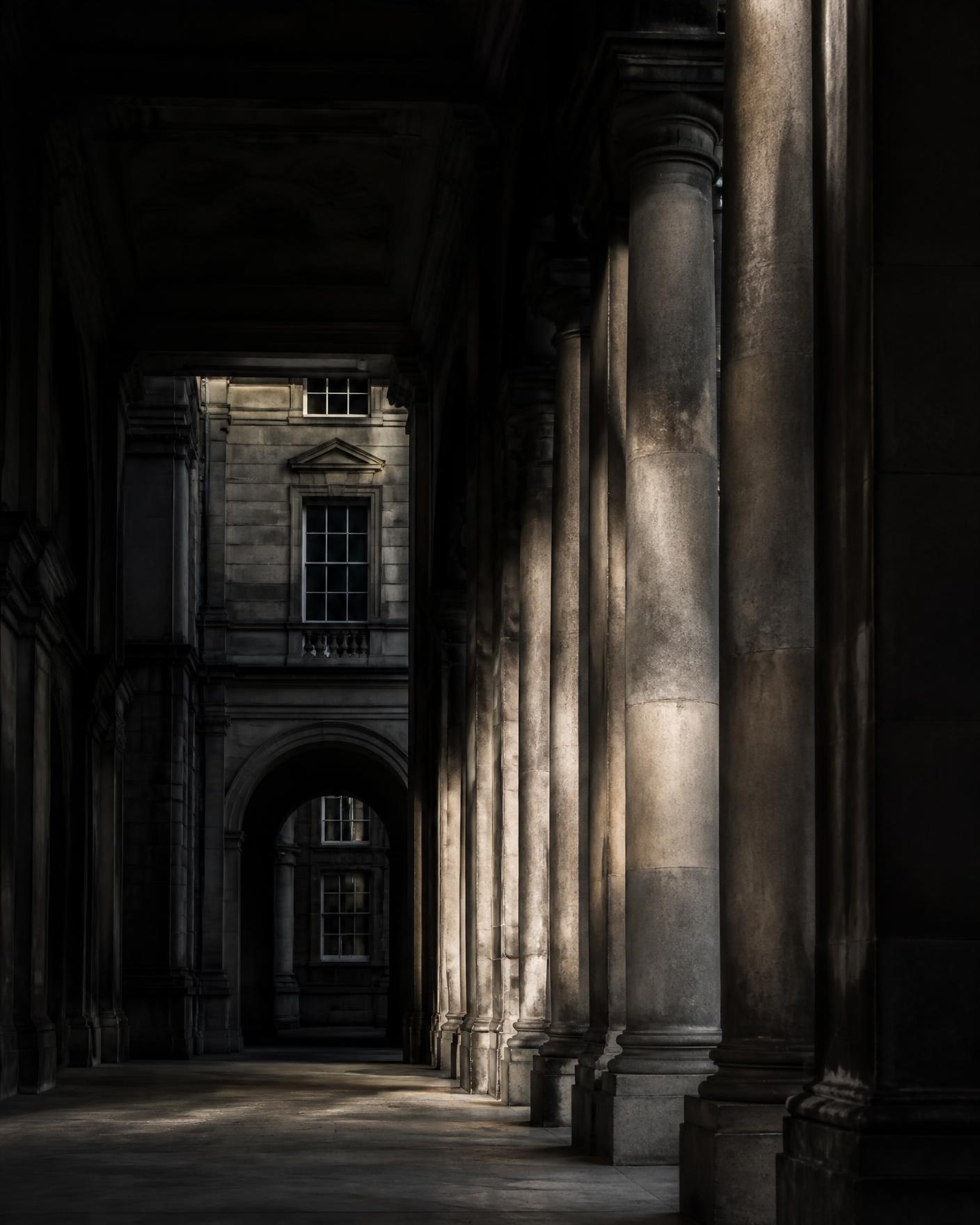 The figure now standing fully within the threshold.